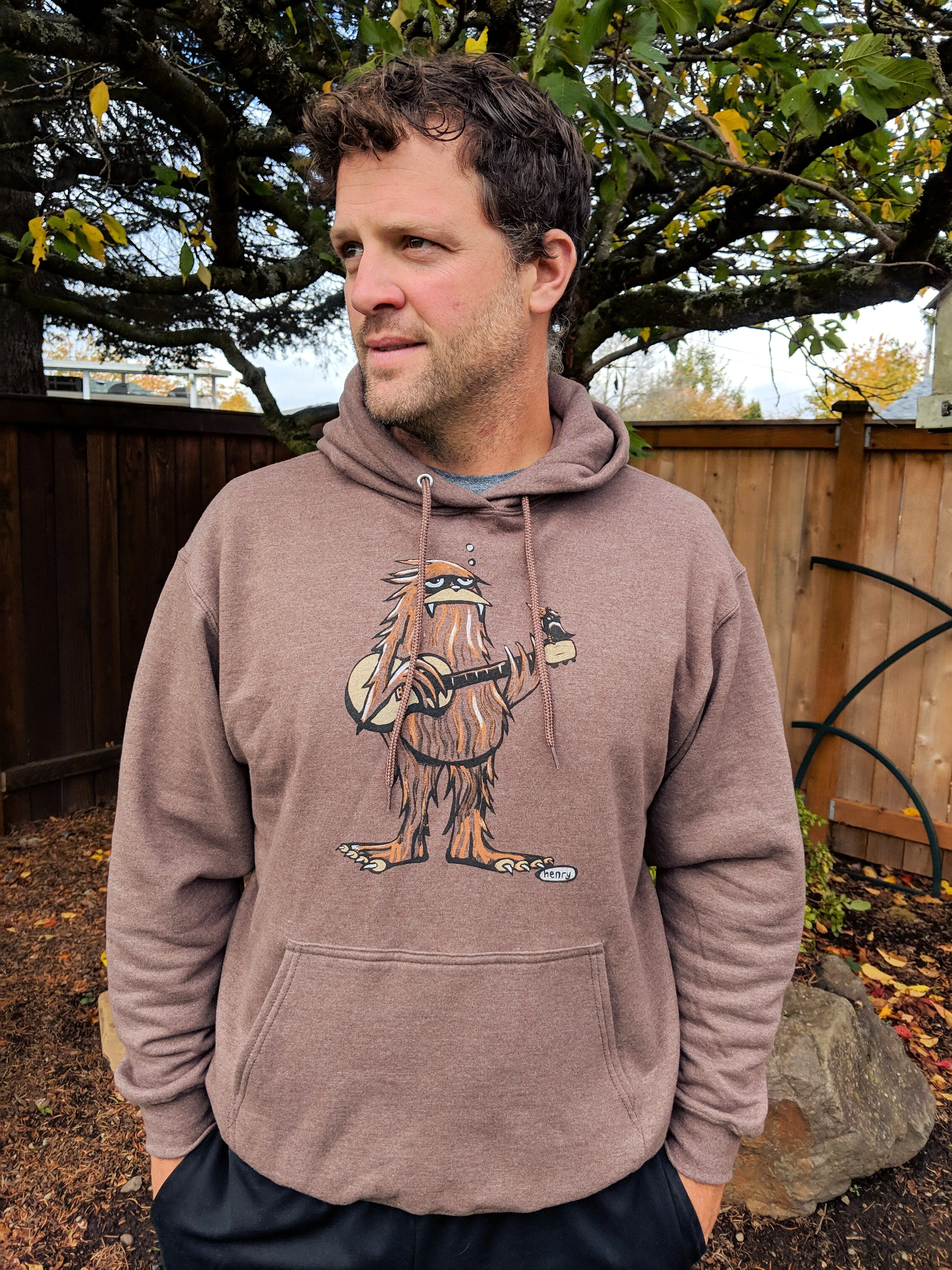 Sasquatch Playing Guitar Heathered Brown Unisex Hoodie | Wearable Art by Seattle Mural Artist Ryan "Henry" Ward